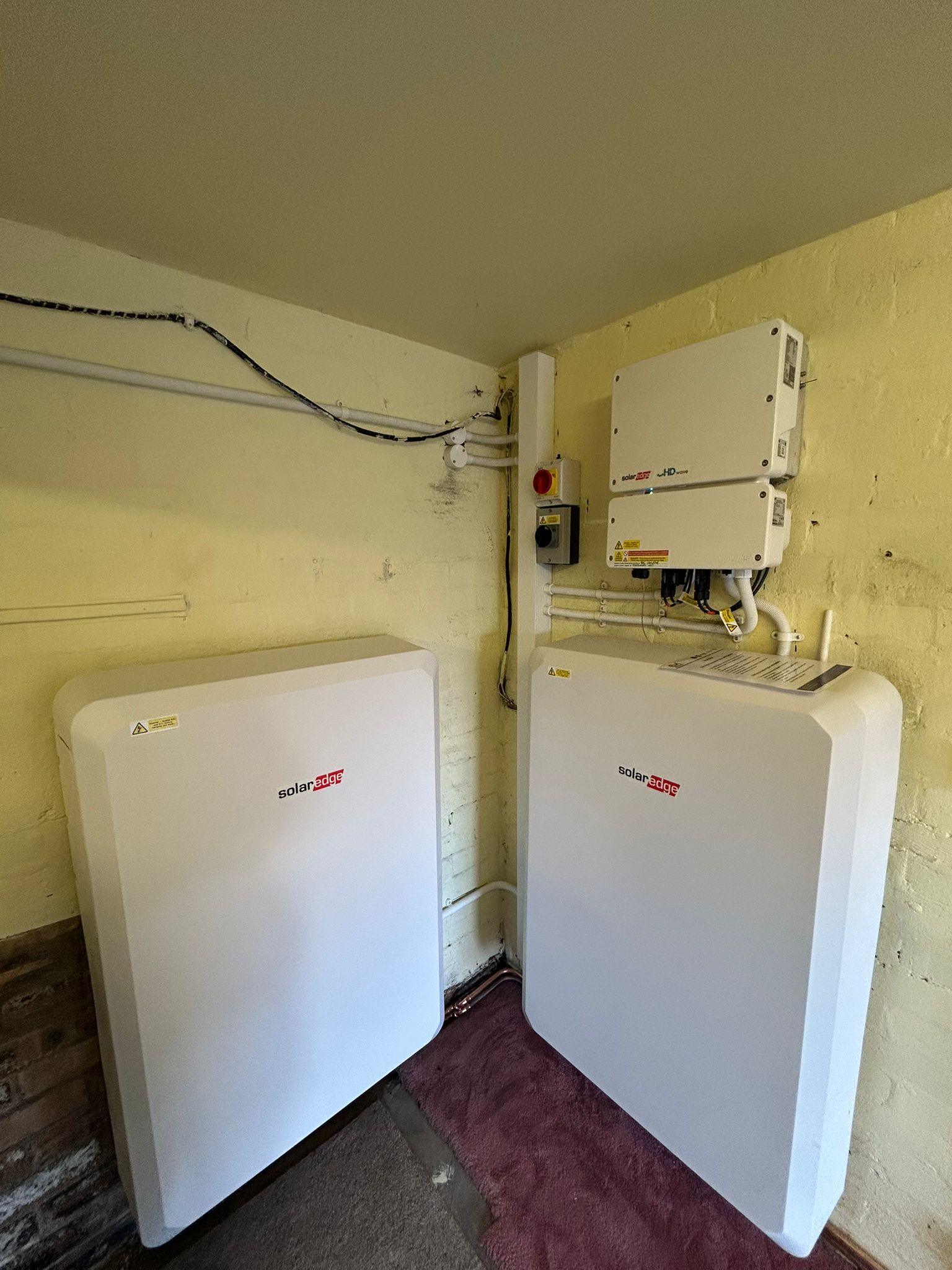 SolarEdge 2x 10kW Home Batts Two SolarEdge 10kW batteries installed in a garage alongside a SolarEdge inverter for a Solar PV array in a house in Scotland